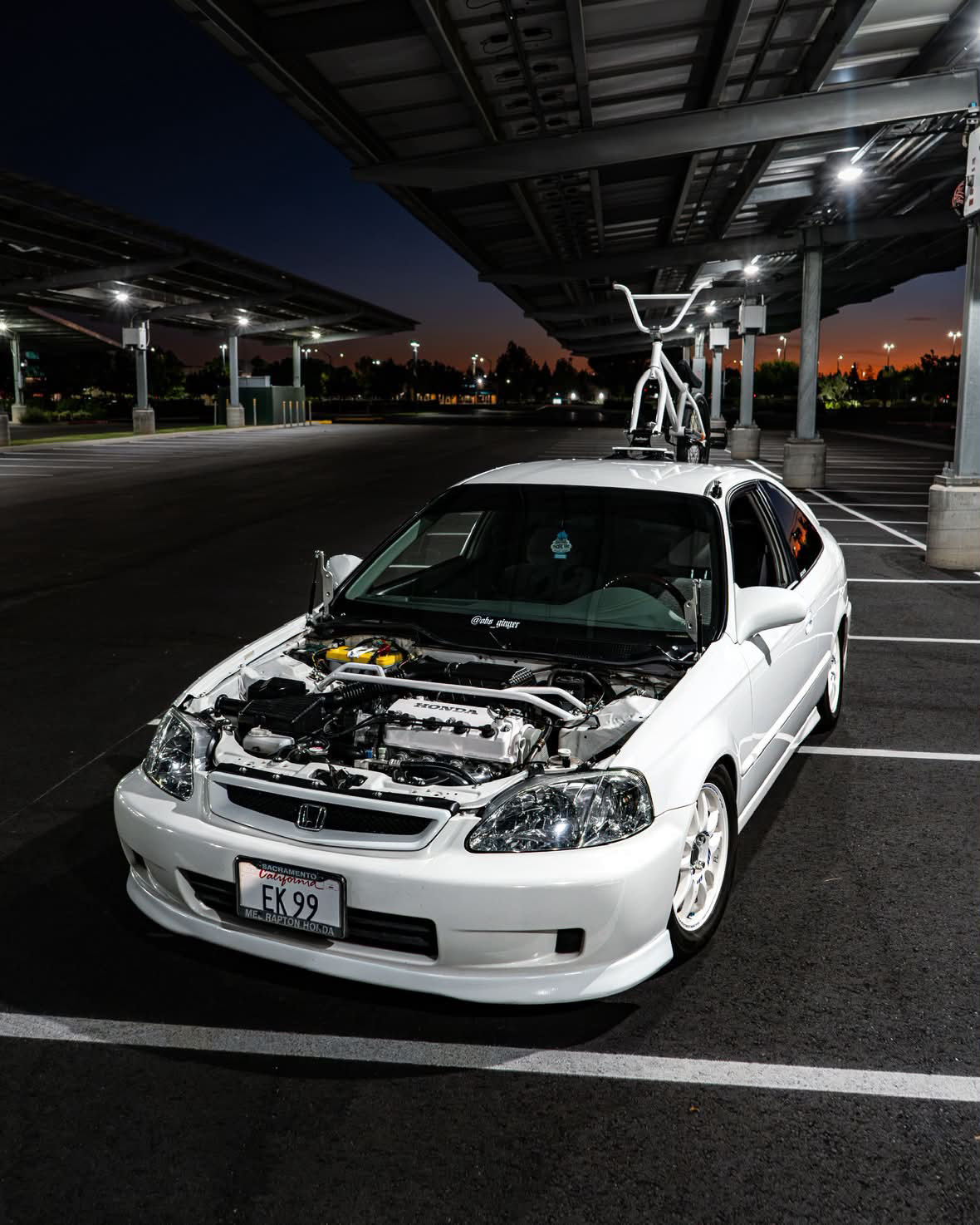 Christian's white Honda Civic at night with a BMX bike on a SeaSucker rack
