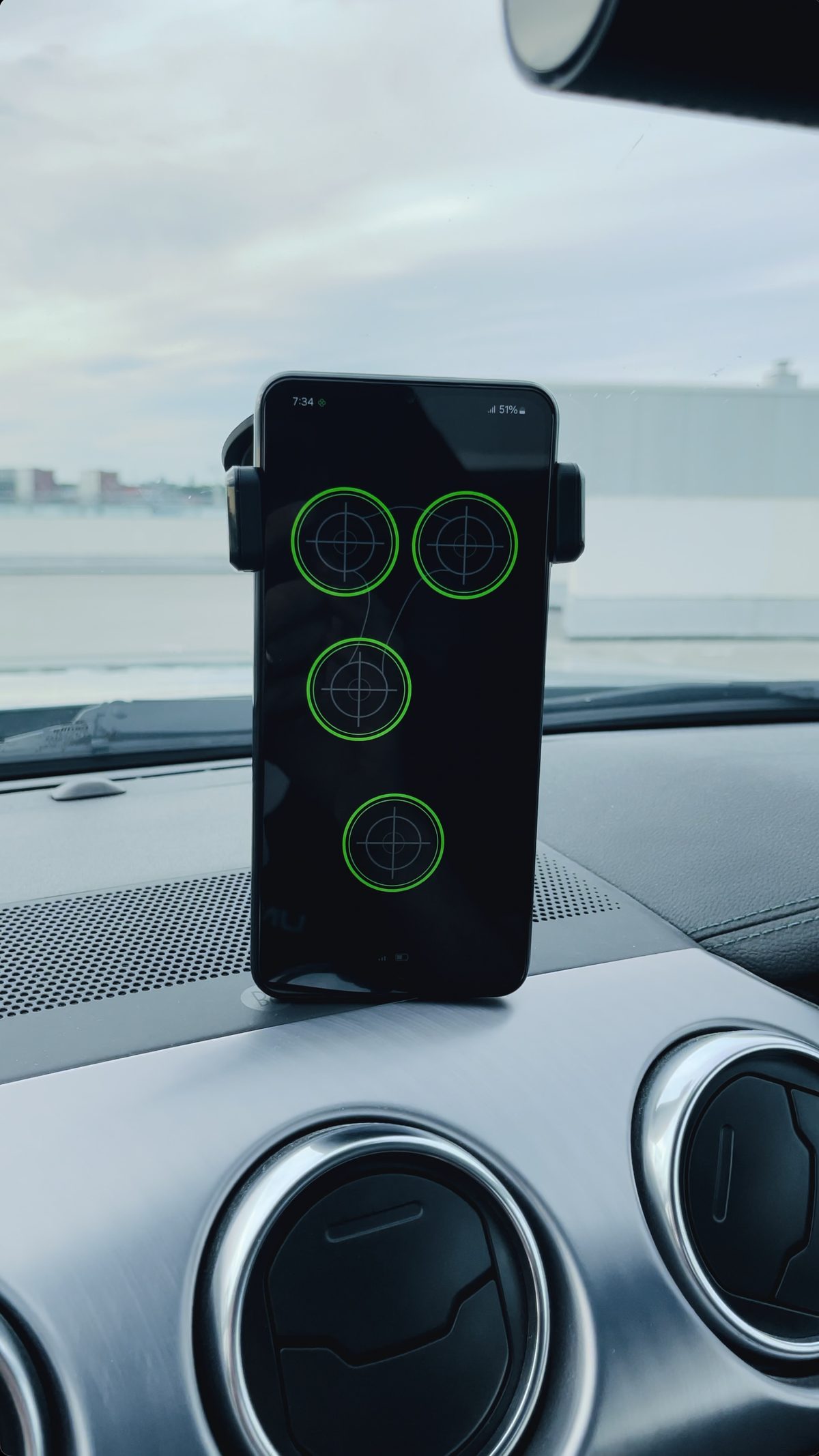 Phone on a car dashboard showing the Kraken app with all mounts secure