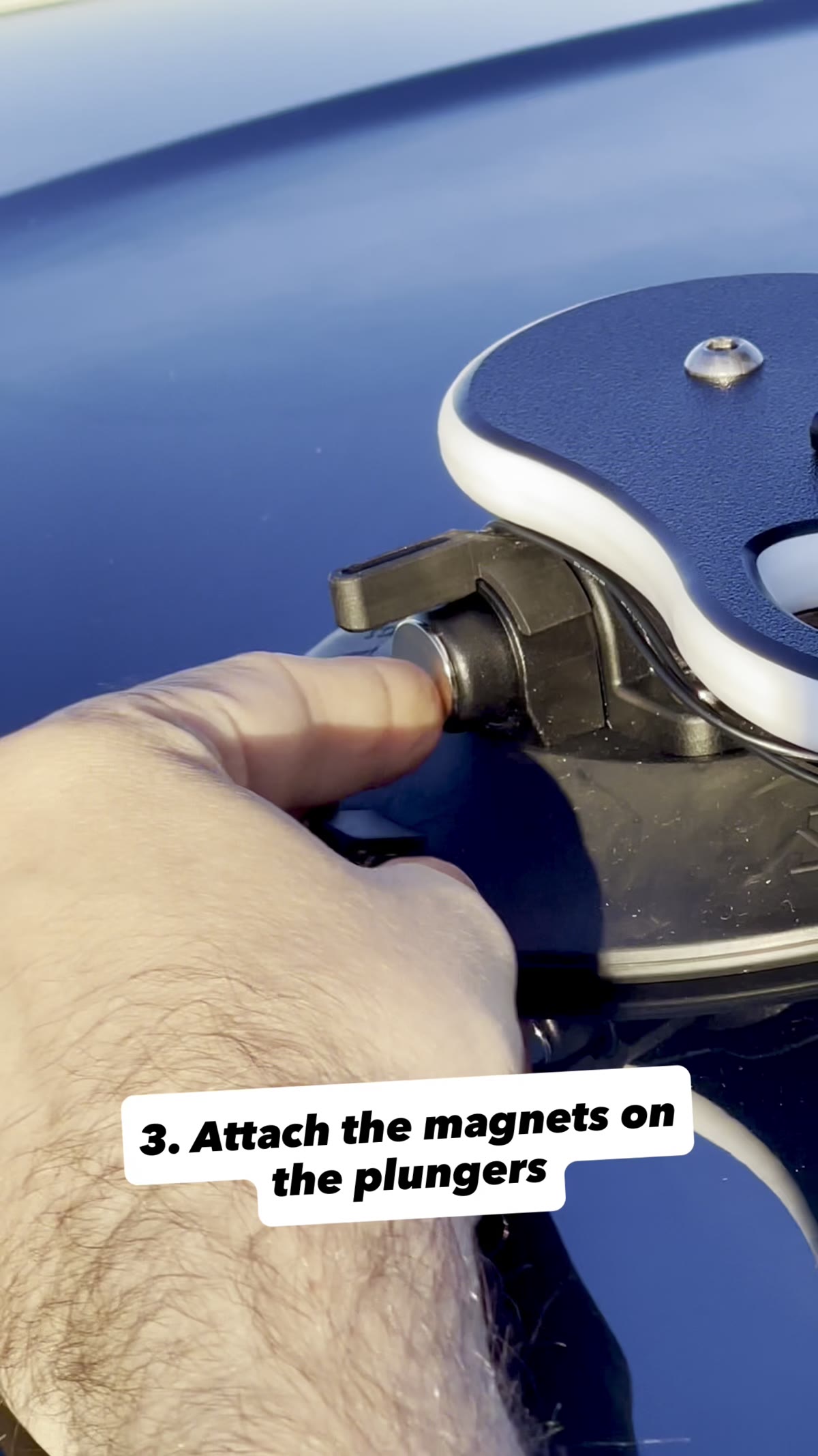 A magnet being placed on the vacuum plunger indicator of a SeaSucker mount